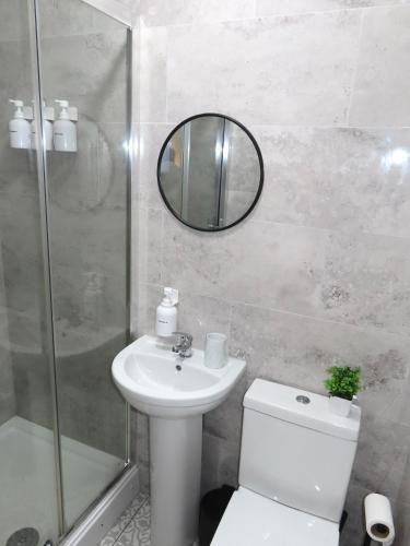 a bathroom with a toilet and a sink and a mirror at 6 Mins to NEC & BHX Apartment with FREE Parking in Sheldon