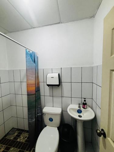 a bathroom with a toilet and a sink at LA CASONA SV Hostal in La Libertad