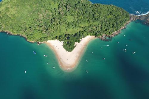 una isla en el océano con barcos en el agua en Passeios de Lancha em Ubatuba - New Mar Turismo, en Ubatuba