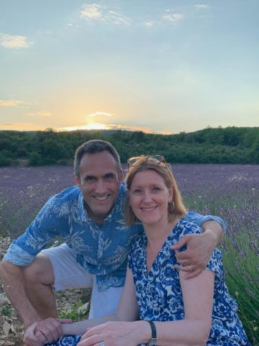 a man and woman sitting in a field of lavender at La Campagne de Lili - Chambre et Cuisine sur Terrasse privée in Ongles