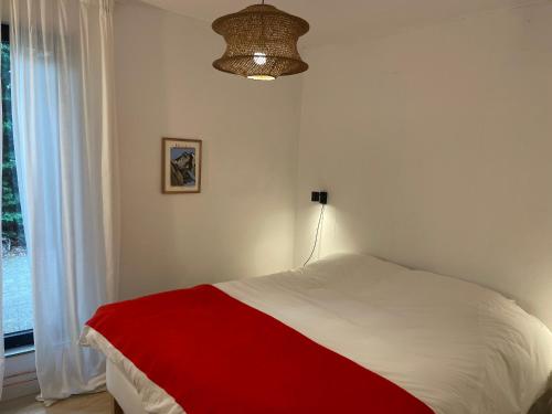 a bedroom with a red and white bed and a window at IJSSELMEER Lake houses in Andijk