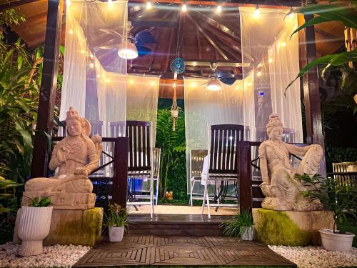 two statues sitting in chairs in a room with lights at ORHO Hotel Boutique 15 minuts PTY Airport free shuttle in Tocumen