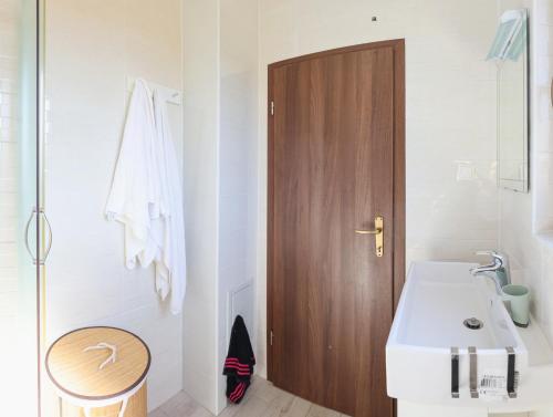Un baño con lavabo y puerta de madera. en Vineyard house, en Tužno