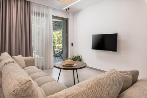 a living room with a couch and a table at Dionisos Luxury Villas in Pefkohori