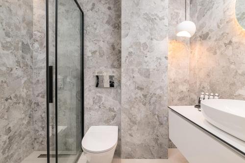 a bathroom with a shower and a toilet and a sink at Dionisos Luxury Villas in Pefkohori