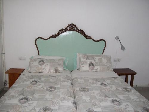 a bed with a headboard and two pillows on it at Apartments Luna 19 in Alcañiz