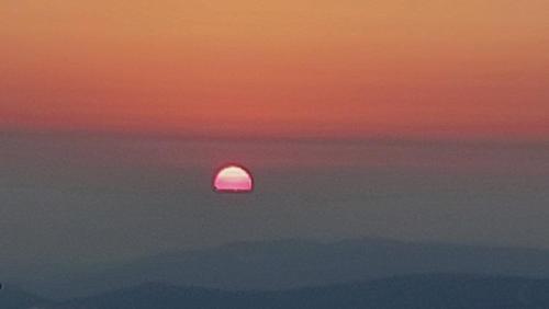 a sunset with the sun in the sky at hararit mountain views in Hararit