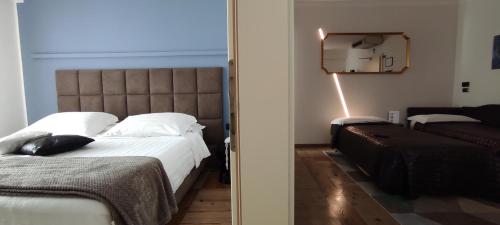 a bedroom with a large bed and a mirror at Hotel Lilla' in Terlago