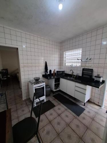 a kitchen with a sink and a counter top at Casa com churrasqueira e piscina in Itanhaém