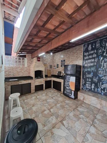 a restaurant with a bar with a chalkboard on the wall at Casa com churrasqueira e piscina in Itanhaém