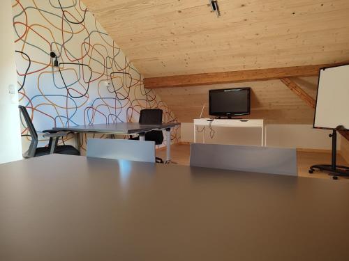 a room with two tables and a tv on a wall at ACCOTINAE in Mont-Saxonnex
