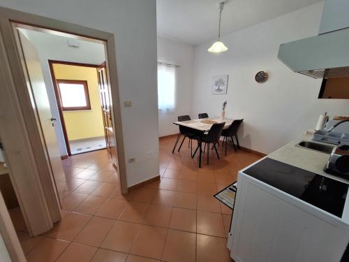 una cucina e una sala da pranzo con tavolo e sedie di Apartment Pergola with Mediterranean Garden & BBQ a Portoroz