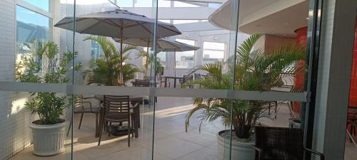 a restaurant with tables and chairs and an umbrella at Hotel Atlântico Tower in Rio de Janeiro
