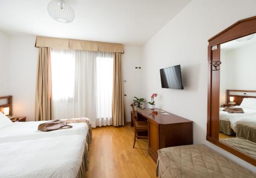 a hotel room with two beds and a mirror at Contra' Contarini in Campolongo Sul Brenta