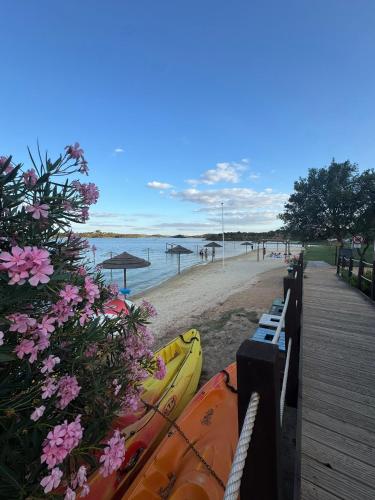 a beach with a boat on the sand and flowers at Casa Sítio do Vale, Alandroal in Alandroal