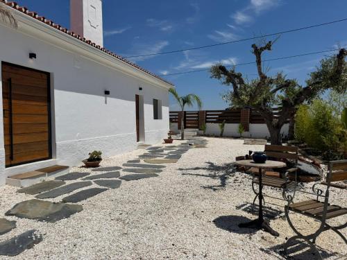 a patio with a table and chairs next to a building at Casa Sítio do Vale, Alandroal in Alandroal