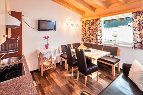 - une cuisine et une salle à manger avec une table et des chaises dans l'établissement Gletscherchalet, à Sankt Leonhard im Pitztal