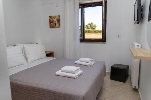 Un dormitorio con una cama con toallas. en Thalori Retreat Areopoli, en Areopoli