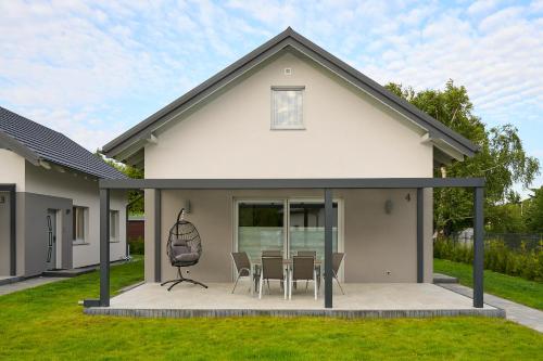 a house with a patio with a table and chairs at Klangor in Kopalino