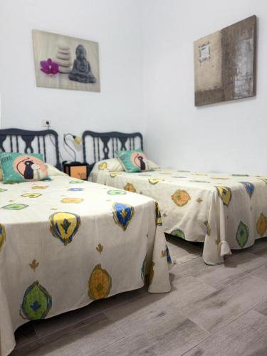 three beds in a room with white sheets at Casa Faican in Agaete