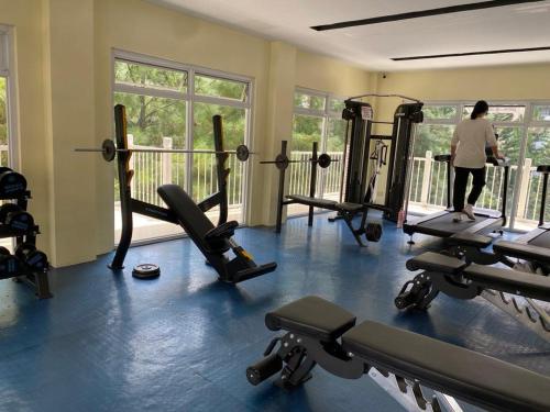 a room with several treadmills and a person walking in a gym at Davao Staycation near abreeza and sm lanang in Davao City