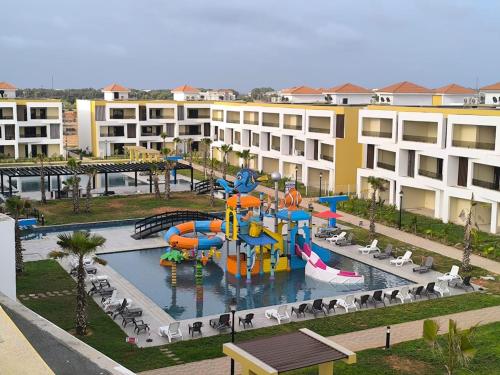 un complexe d'appartements avec un parc aquatique doté d'un toboggan. dans l'établissement Évasion Haut Standing à Saïdia, à Saïdia
