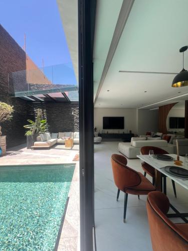 a living room with a swimming pool and a house at Duplex de luxe, piscine sauna in Marrakech
