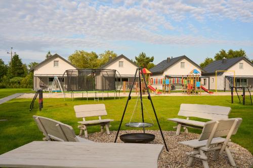 a park with a playground with a picnic table and chairs at Klangor in Kopalino
