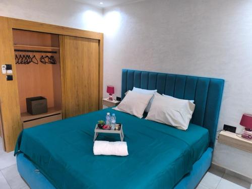 - une chambre avec un lit bleu et une table de chevet dans l'établissement Évasion Haut Standing à Saïdia, à Saïdia