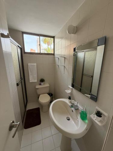 een witte badkamer met een wastafel en een toilet bij Barrio El Golf Apartment in Barranquilla