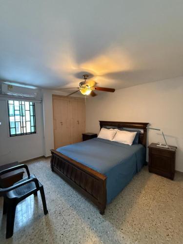 een slaapkamer met een bed en een plafondventilator bij Barrio El Golf Apartment in Barranquilla