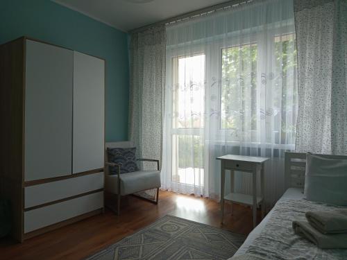 a bedroom with a bed and a desk and a window at Husarska Swinemünde in Świnoujście