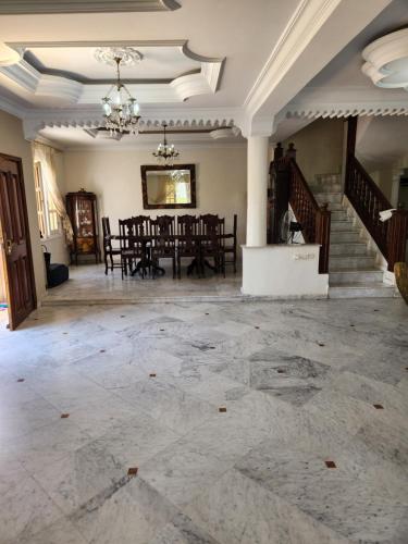 a large room with a table and chairs in it at Villa mouna in Mohammedia