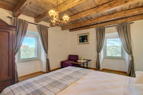 a bedroom with a bed and two windows at Villa Onorina in Pomer