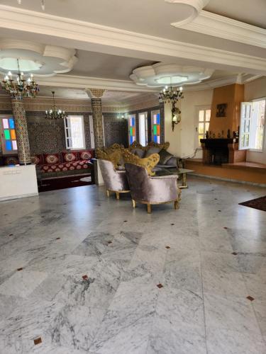 a large living room with couches and a piano at Villa mouna in Mohammedia