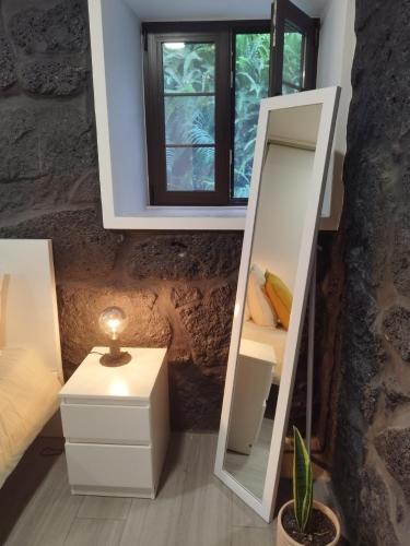 a mirror in a room with a bed and a window at Drop Point in Santo Amaro
