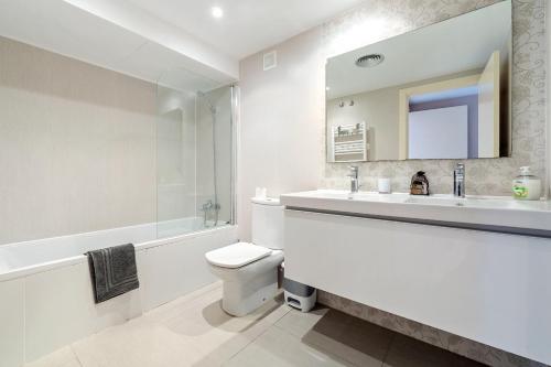 a white bathroom with a sink and a toilet at Aqquaria Lujoso in Salou