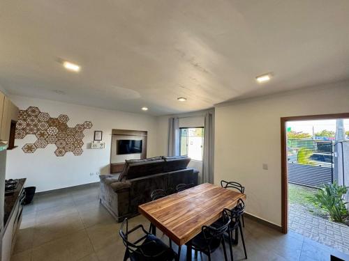 Una sala de estar con una mesa y un piano. en Casa com piscina - Shangri-lá, en Pontal do Paraná