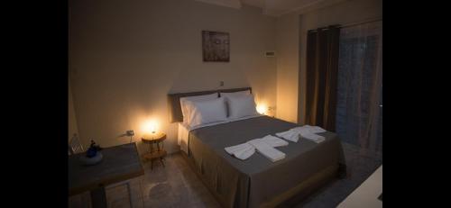 a bedroom with a bed with towels on it at Ενοικιαζόμενα δωμάτια ΣΟΛΩΝΑΣ in Mytilini