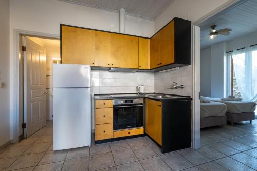 a kitchen with a white refrigerator and a stove at Mythos Suites-Dionysos apartment in Methoni