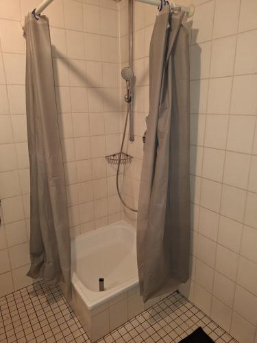 a shower in a tiled bathroom with a tub at Apartment B&J Cochem in Cochem