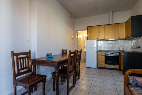 a kitchen with a table and chairs and a refrigerator at Mythos Suites-Dionysos apartment in Methoni
