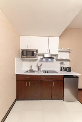 a kitchen with a sink and a microwave at Clarion Suites Guatemala City in Guatemala