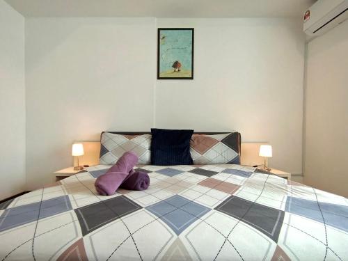 Un dormitorio con una cama grande con almohadas moradas. en BBHomes at Bukit Bintang Casa Residency KL, en Kuala Lumpur