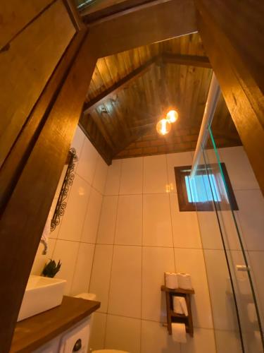a bathroom with a toilet and a wooden ceiling at Cabana 3 Fazenda in São Francisco de Paula