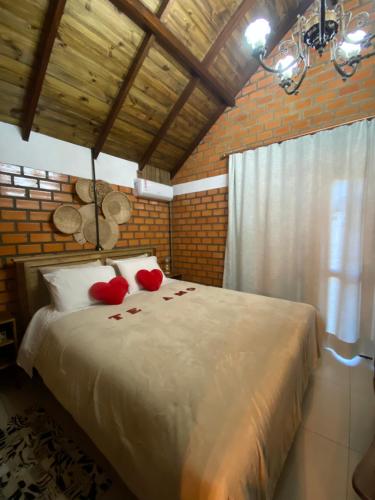 a bedroom with a bed with red roses on it at Cabana 3 Fazenda in São Francisco de Paula