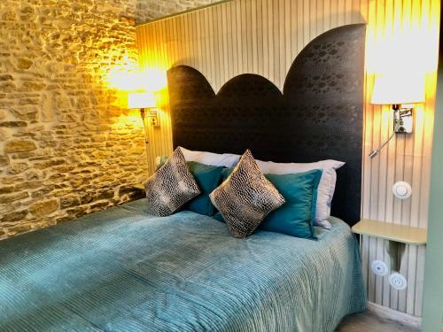 a bedroom with a bed with pillows on it at Les Fleurs De Lys, Suite'Appart , Entrée et Terrasse Privée Proche de la Mer in Saint-Georges-dʼOléron