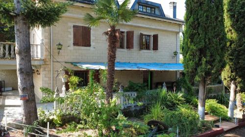 a house with palm trees in front of it at Hotel Rural Camino Medulas in Ponferrada