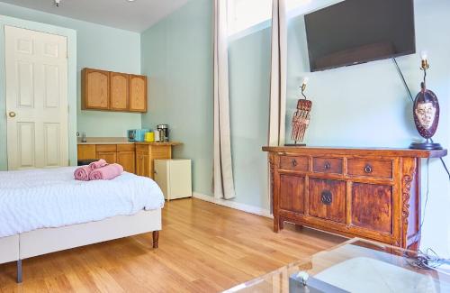 a bedroom with a bed and a dresser with a tv at Malibu Getaway - Studio Unit In Nature, Close To Beach in Malibu