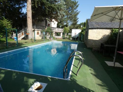 a swimming pool in the yard of a house at Hotel Rural Camino Medulas in Ponferrada